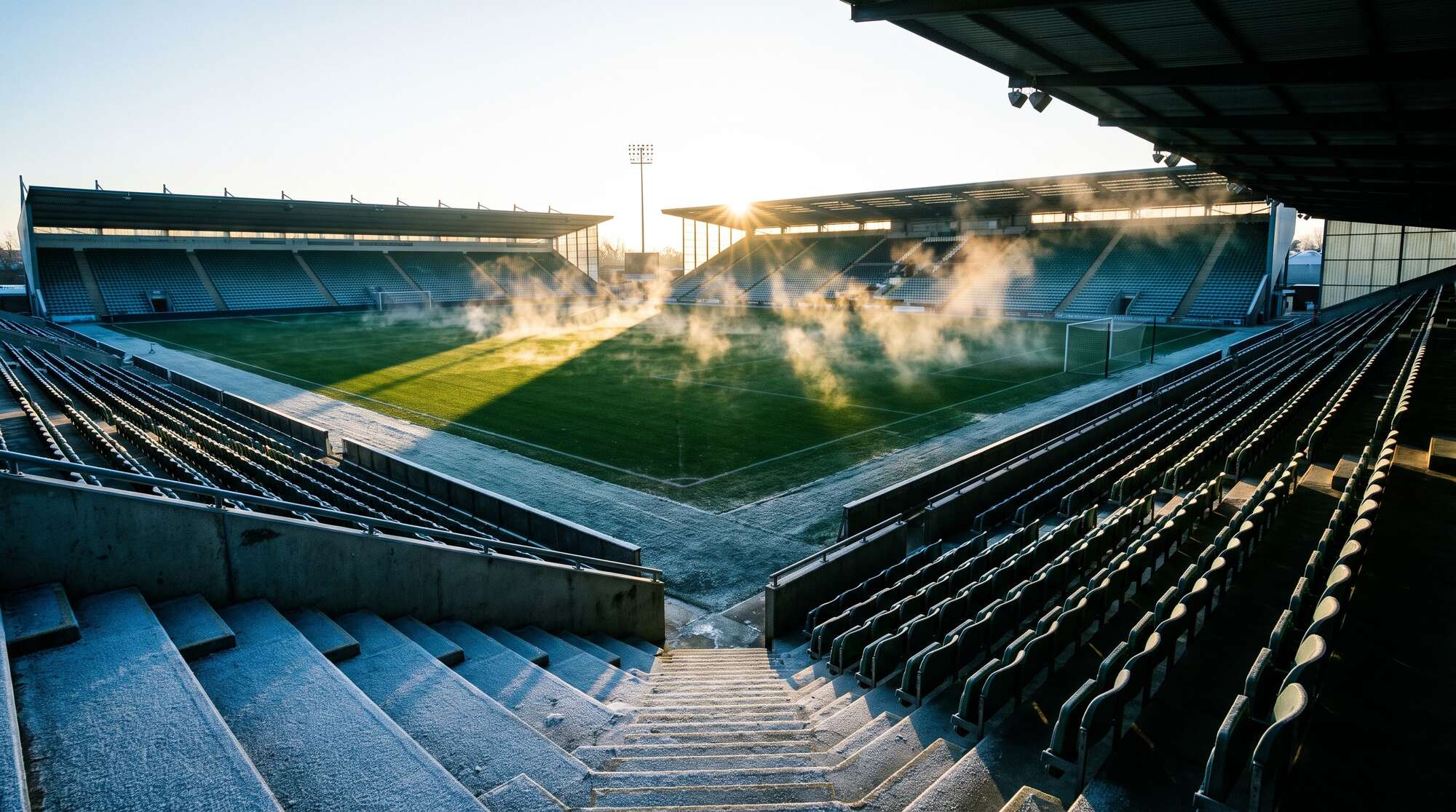Frost auf den Sitzen, der beheizte Rasen dampft in der Morgensonne